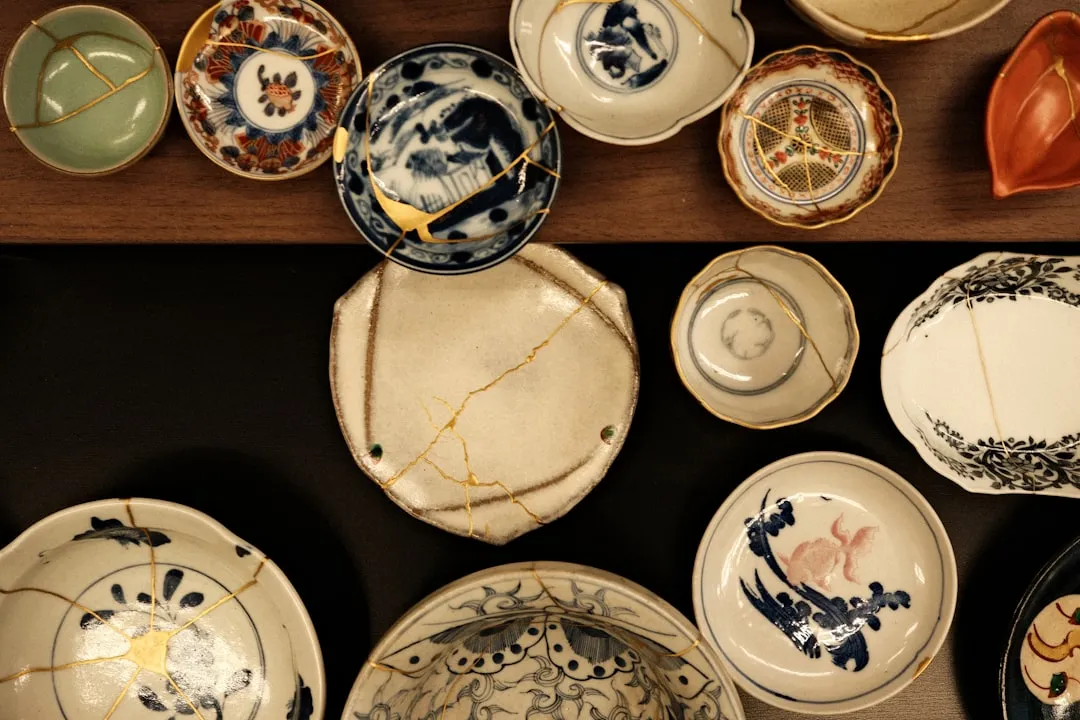 Collection of ceramic dishes, many repaired with gold kintsugi.